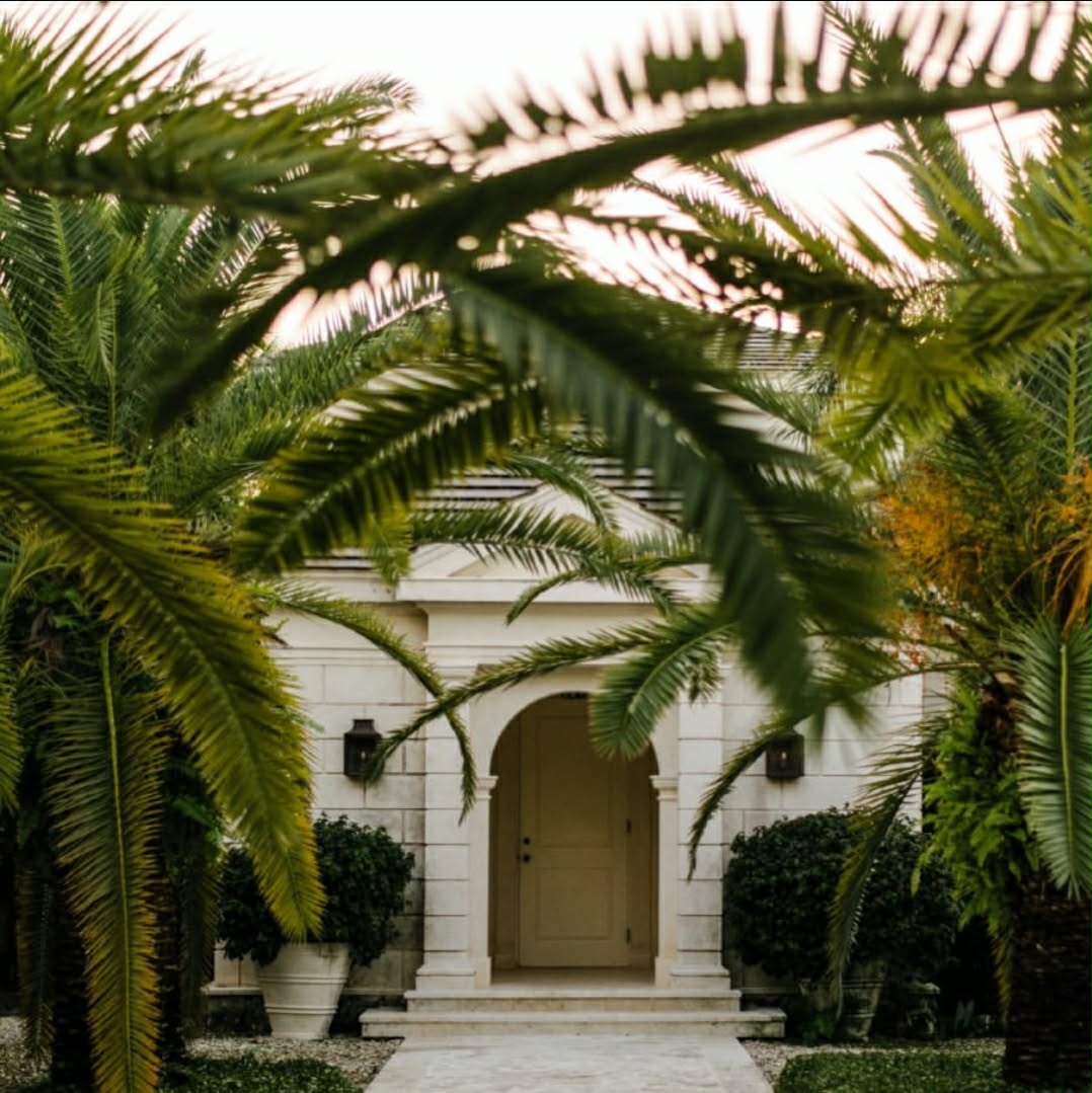 Grand ivory residence framed by mature palm trees